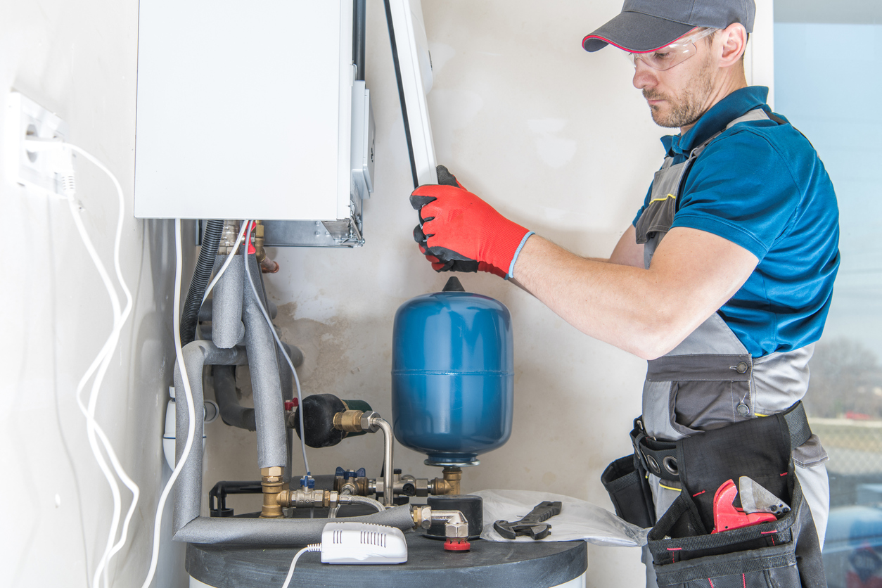 HVAC technician replacing the face of a gas heating system