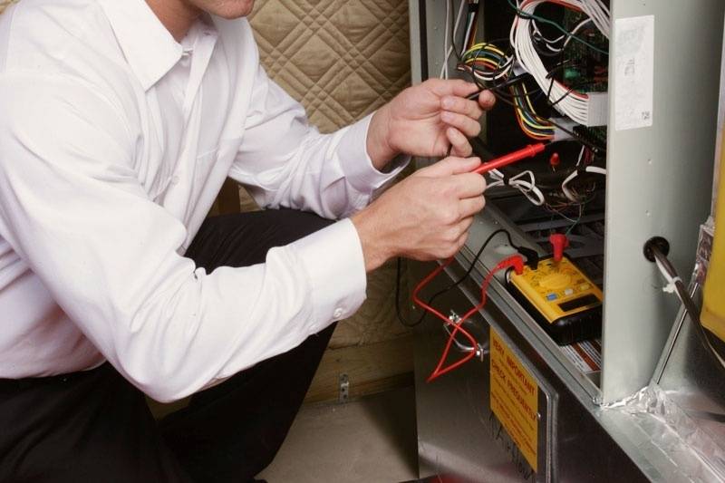 HVAC technician working on a furnace that needs professional service