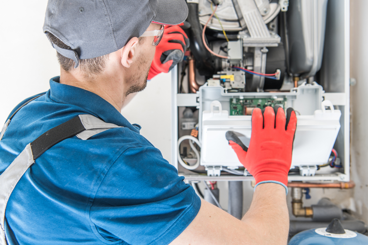 HVAC technician working on a gas furnace in an Illinois home