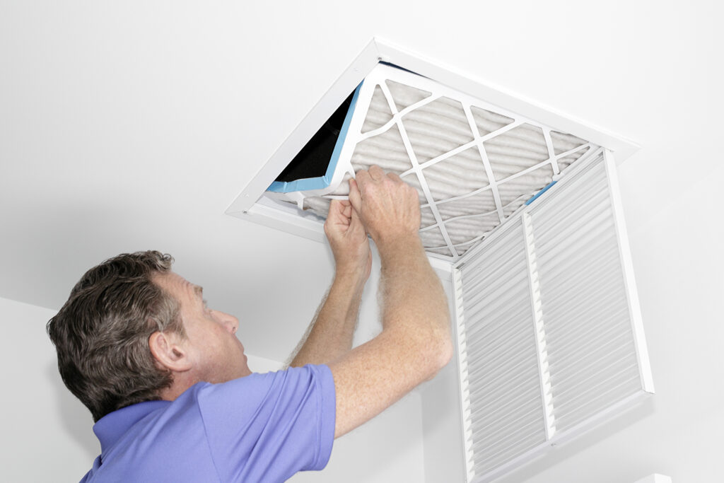 HVAC technician changing an air filter in someone’s home